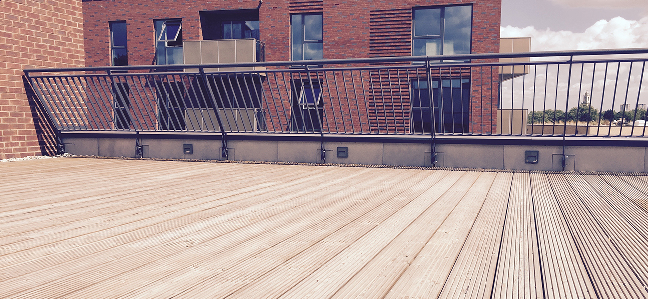 Timber decking used on a terrace with a black fence