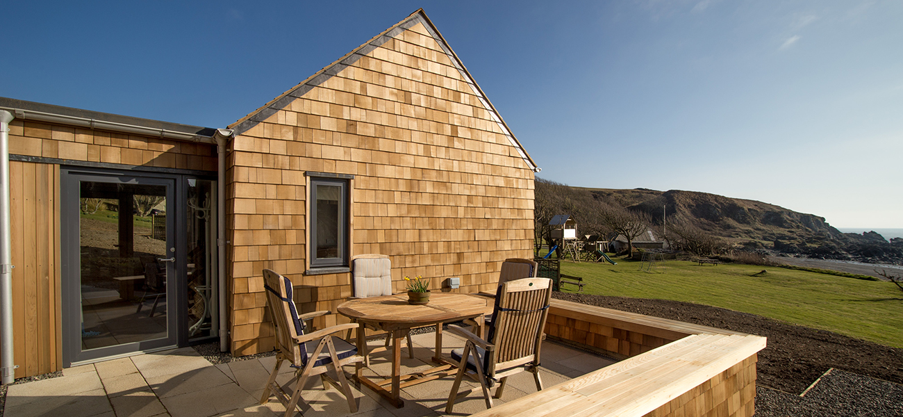 House built with Shingles with a terrace in timber