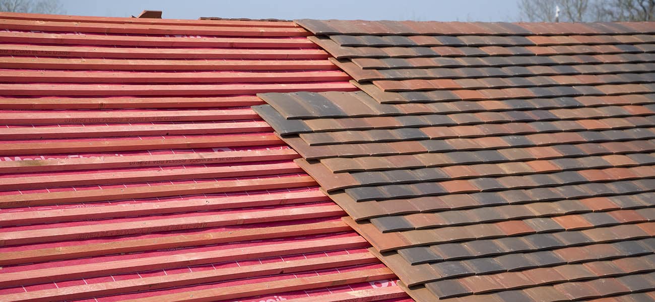 Work in progress on a roof with clay tiles