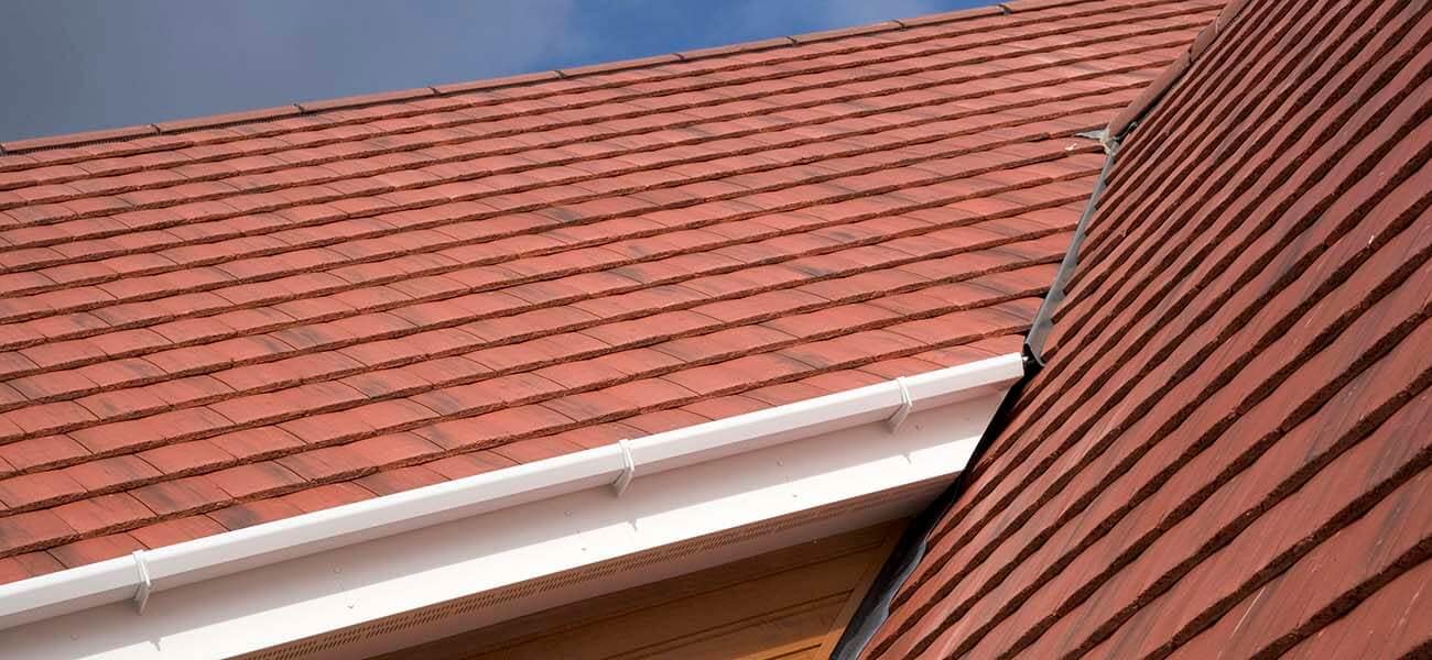 Concrete roof tiles on a pitched roof, showing overlapping installation and detailing for weather resistance and durability