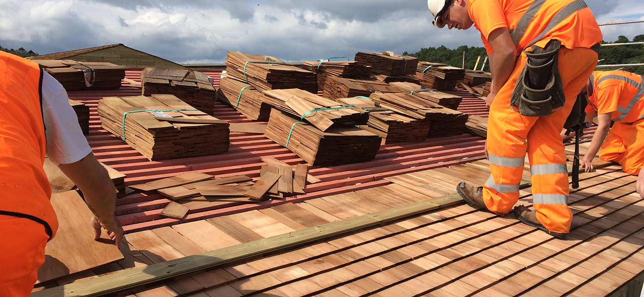 Roofers working on a roof with shingles