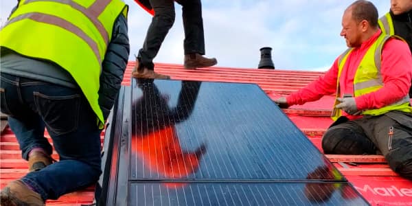 roofers installing solar panels on roof