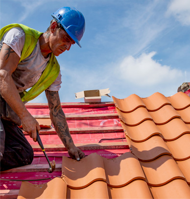 Roofer working on roof tiles