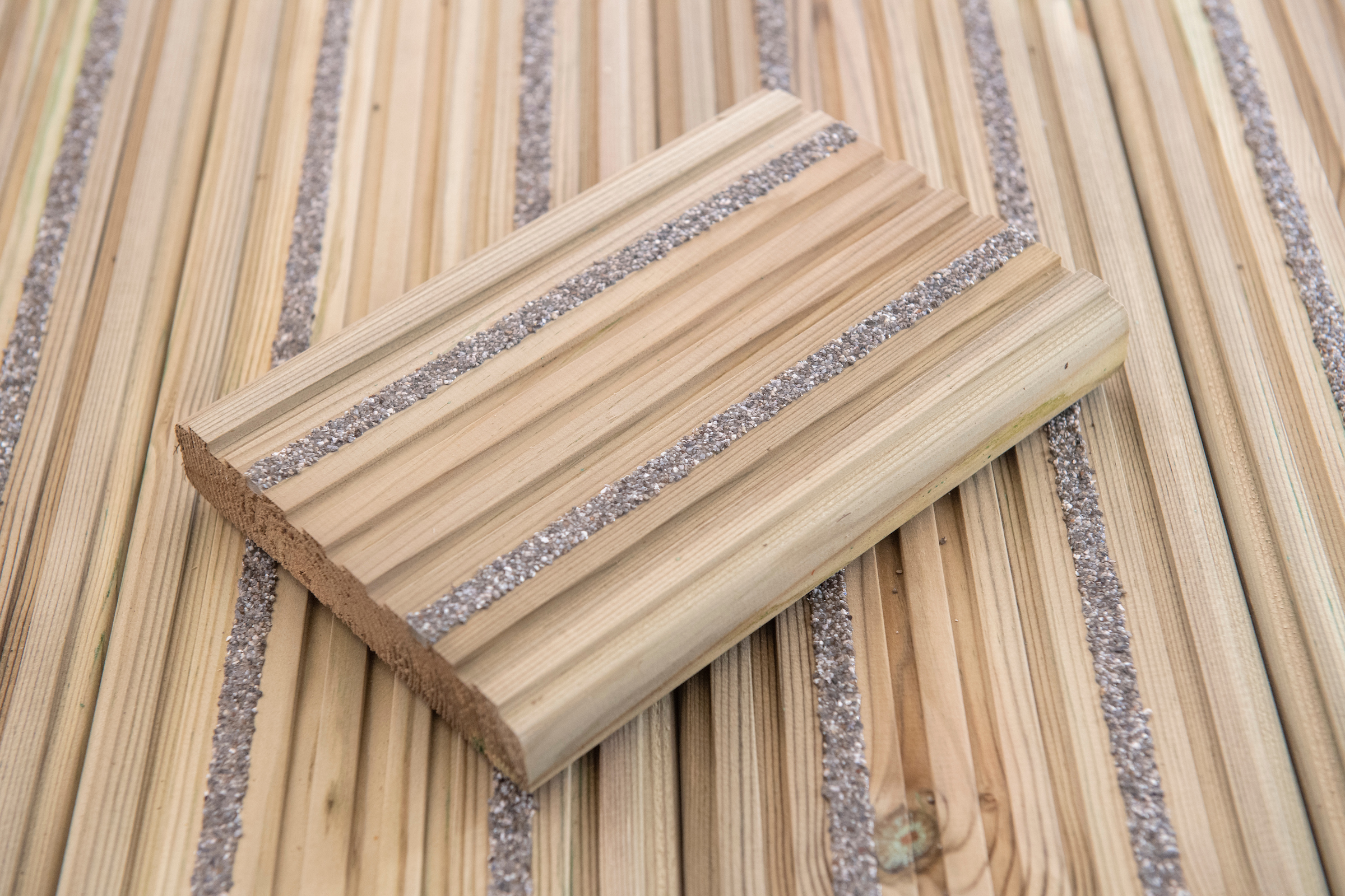 A close up image of a plank of anti-slip decking, showing the varying textures of the decking.