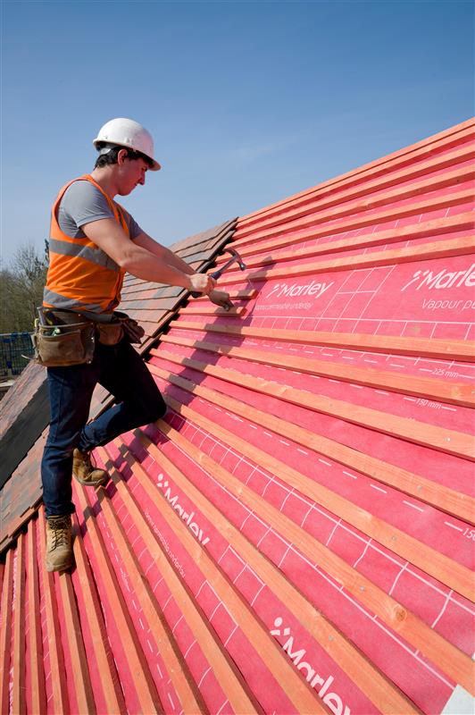Image showing a man nailing roof tiles on JB red batten