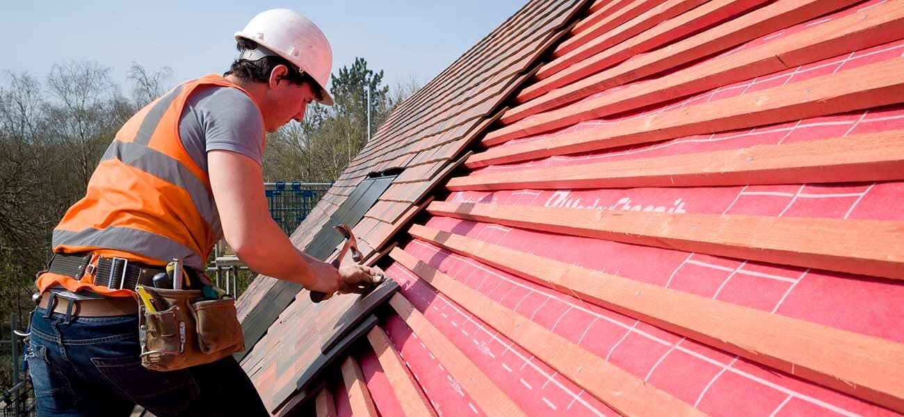 Image showing a man nailing roof tiles on JB red batten